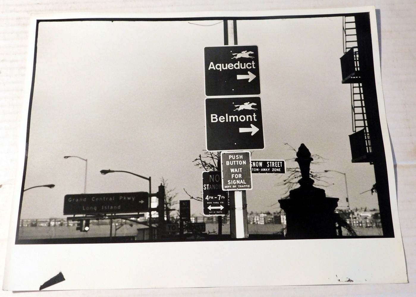 [SNOW STREET WITH SIGNS TO AQUEDUCT & BELMONT HORSE RACING TRACKS]: AN ORIGINAL PHOTOGRAPH by the American Photographer CHARLES HARBUTT.